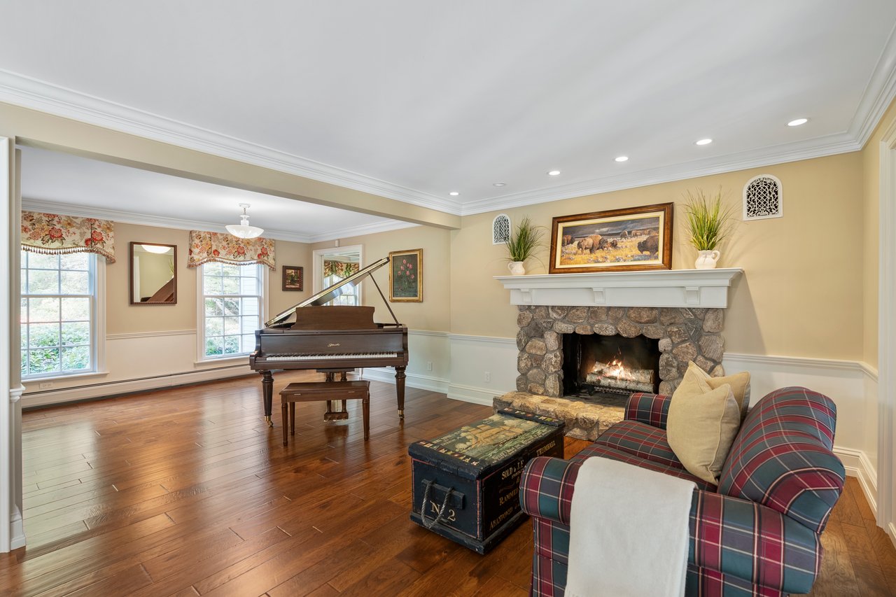 Sunlit front to back living room with fieldstone fireplace