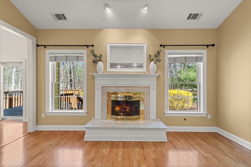 Custom gas log fireplace flanked by two large windows that bring the outside in