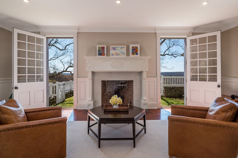 This formal living room just off the foyer has a wood burning fireplace along with doors that welcome you to a garden area.