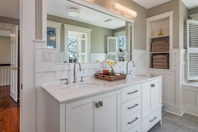 Double sinks, ample storage, and lots of natural light highlight this primary bath.