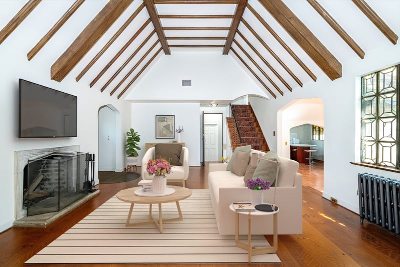 Virtually staged photo. Living room with wood burning fireplace.