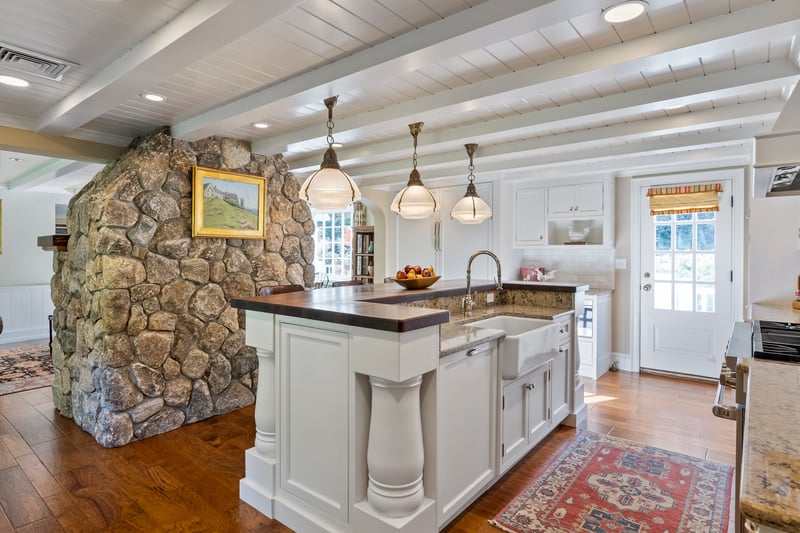 Enjoy an open view from kitchen into family room anchored by a warm fieldstone fireplace