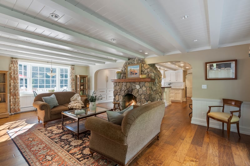 Shiplap ceiling and beams extend through a sunny breakfast nook and the family room