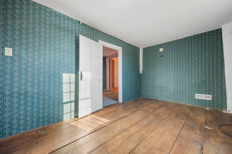 Upstairs bedroom with wide board floors.