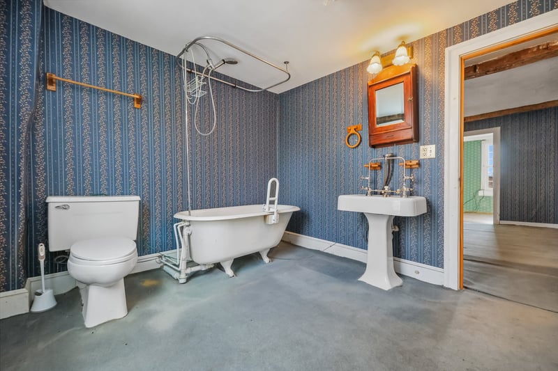 The upstairs bathroom is large, with vintage fixtures.